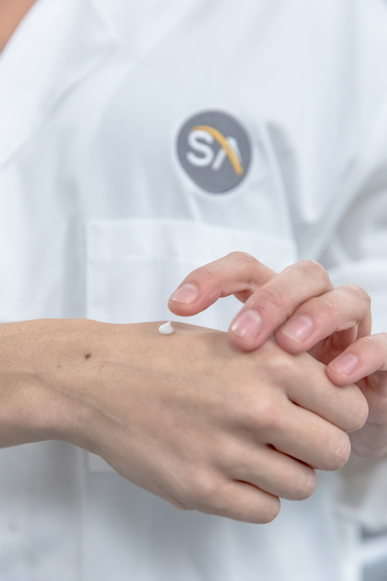 Swiss-American employee applying lotion to their hand.